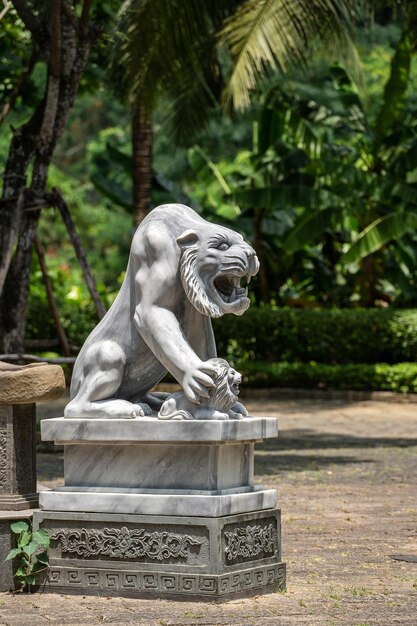 Tigre branco de mármore e estátua de leão no parque ao ar livre no jardim tropical Vietnã