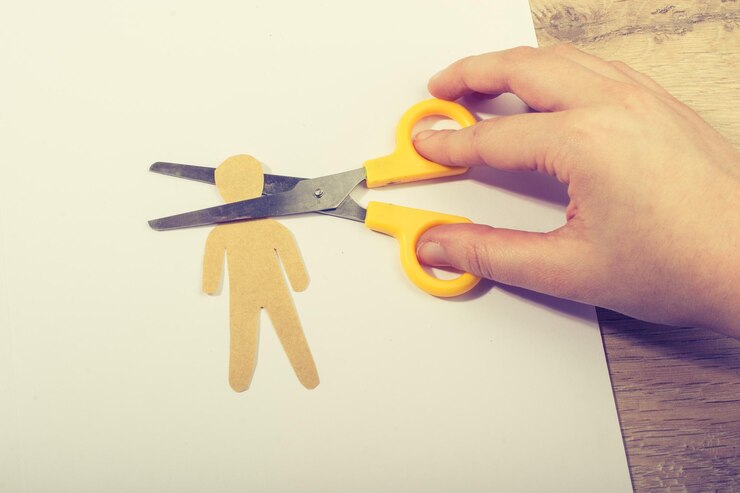 Foto tijeras cortando la cabeza del hombre de papel sobre papel blanco