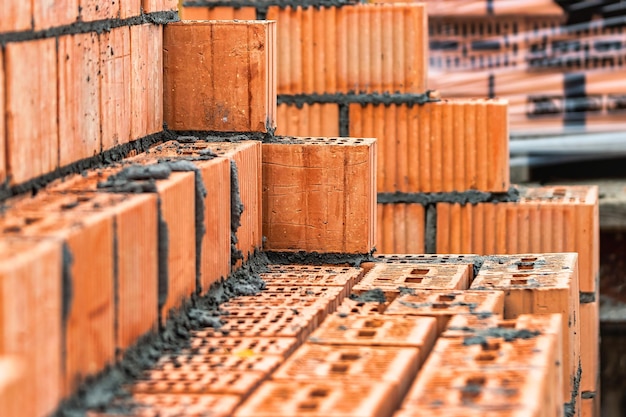 Tijolos cerâmicos vermelhos no canteiro de obras keramoblock tijolo oco construção de um edifício de tijolo vermelho closeup material para a construção de paredes e divisórias