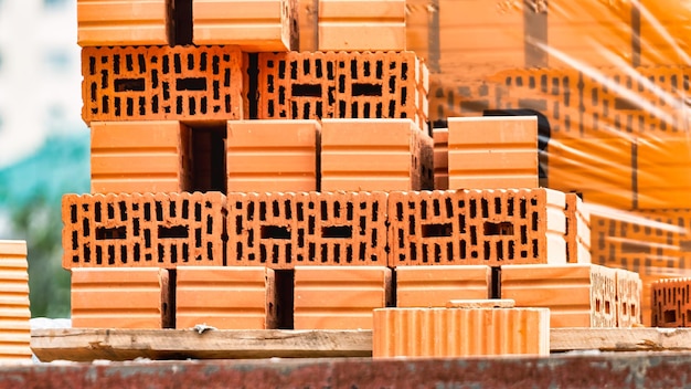 Tijolos cerâmicos vermelhos no canteiro de obras keramoblock tijolo oco construção de um edifício de tijolo vermelho closeup material para a construção de paredes e divisórias