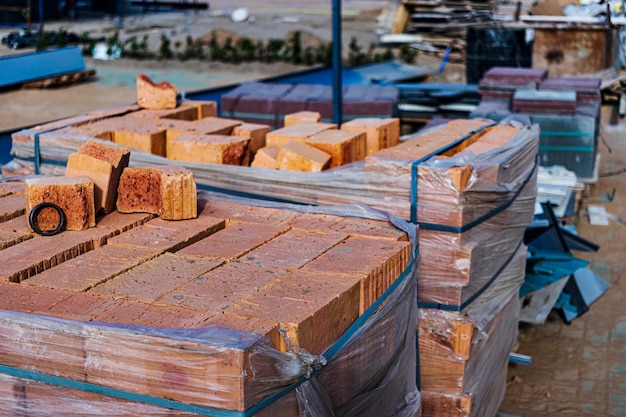 Tijolos em paletes em um canteiro de obras. materiais de construção. tijolo vermelho para construir uma casa.