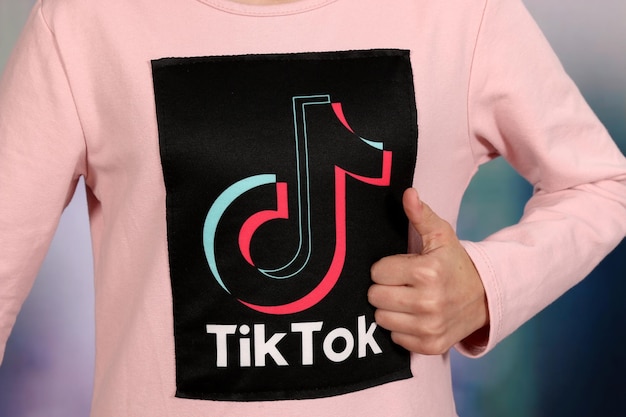 Foto tik tok-symbol social-media-logo auf rosa mädchen-t-shirt. tik tok-logo-design.