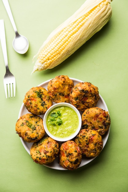 Tikki de maíz crujiente, pakora o pakoda o pattice también conocido como chuleta. servido con chutney verde. Enfoque selectivo