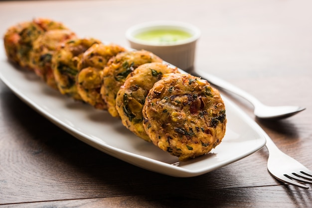 Tikki de maíz crujiente, pakora o pakoda o pattice también conocido como chuleta. servido con chutney verde. Enfoque selectivo