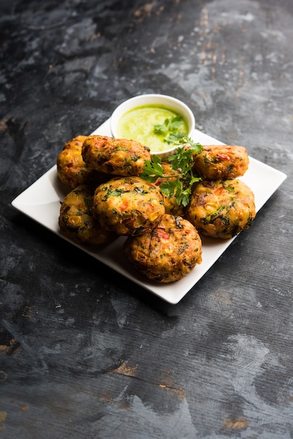 Tikki de maíz crujiente, pakora o pakoda o pattice también conocido como chuleta. servido con chutney verde. Enfoque selectivo