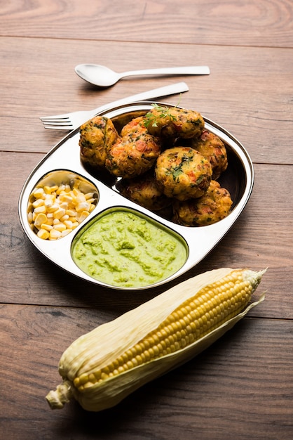 Tikki de maíz crujiente, pakora o pakoda o pattice también conocido como chuleta. servido con chutney verde. Enfoque selectivo