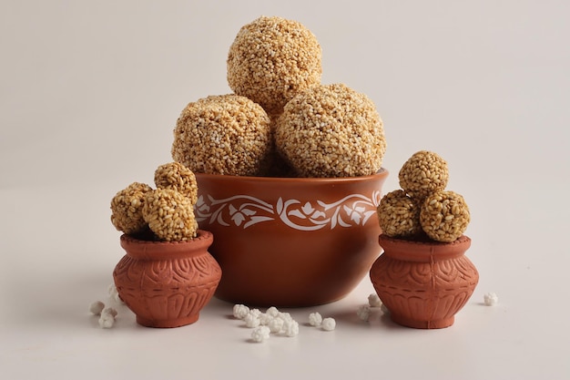 Til Gul O bola de semillas de sésamo dulce o Laddu con Fikri para el festival indio Makar Sankranti sobre fondo blanco