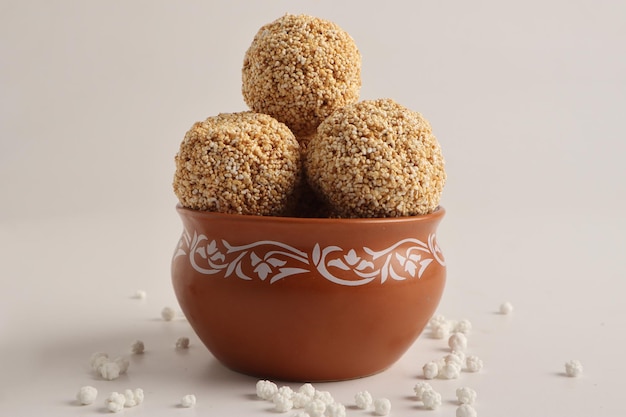 Til Gul ODER süße Sesamkugel oder Laddu mit Fikri für das indische Festival Makar Sankranti auf weißem Hintergrund