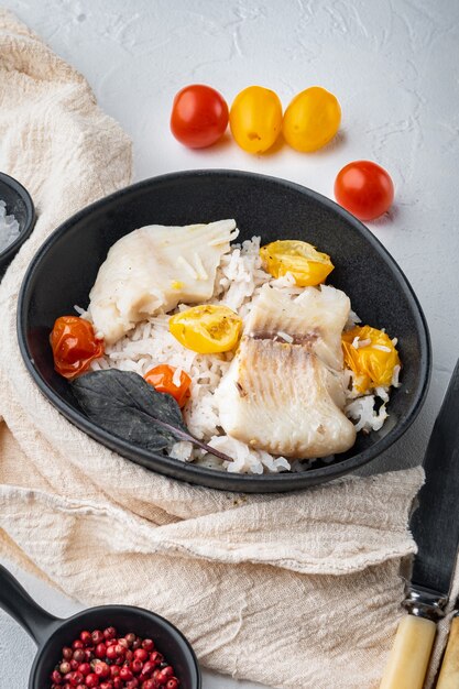 Tilapia-Fisch mit Basmatireis und Kirschtomaten, in Schüssel, auf weißem Tisch