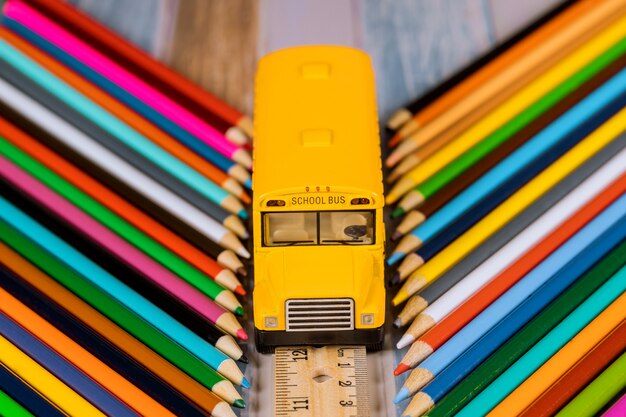 Útiles escolares, lápices de colores y autobús escolar de juguete. Concepto de educación