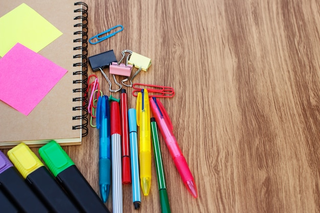 Útiles escolares en una mesa de madera con espacio para texto