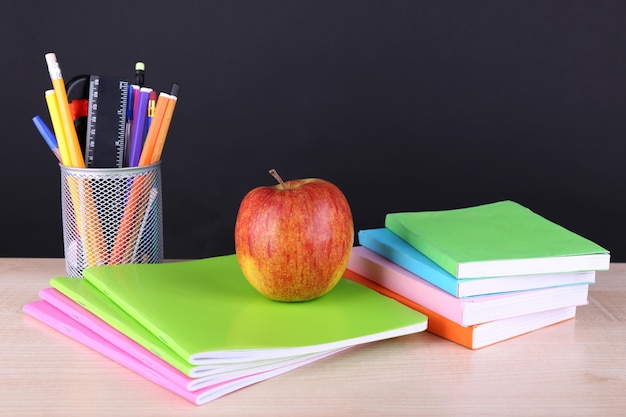 Útiles escolares en la mesa sobre fondo oscuro