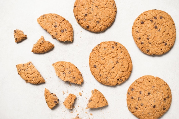 Útiles galletas de cereales con frutas secas y migas de chocolate sobre una mesa de fondo blanco claro Vista desde arriba Galleta con frutas confitadas y cerezas Comida plana Vista superior Aislar Cerrar