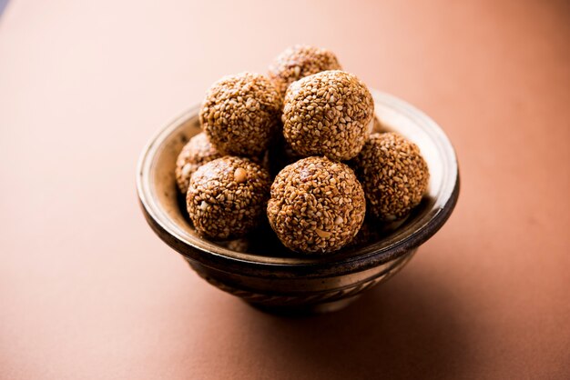 Tilgul Laddu o Til Gul balls para makar sankranti, es un alimento saludable elaborado con sésamo, maní triturado y azúcar moreno. servido en un bol. enfoque selectivo que muestra detalles.