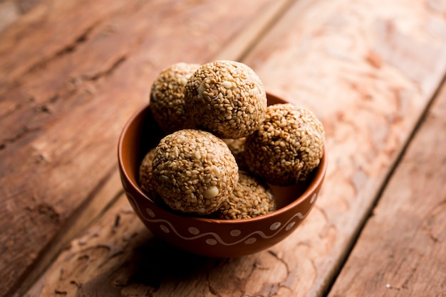 Tilgul Laddu o Til Gul balls para makar sankranti, es un alimento saludable elaborado con sésamo, maní triturado y azúcar moreno. servido en un bol. enfoque selectivo que muestra detalles.