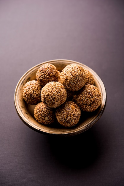 Tilgul Laddu oder Til Gul Kugeln für Makar Sankranti, es ist ein gesundes Essen aus Sesam, zerstoßenen Erdnüssen und Jaggery. in einer Schüssel serviert. selektiver Fokus mit Details.