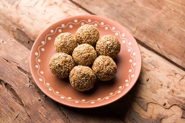 Tilgul Laddu ou Til Gul balls para makar sankranti, é um alimento saudável feito com gergelim, amendoim esmagado e açúcar mascavo. servido em uma tigela. foco seletivo mostrando detalhes.