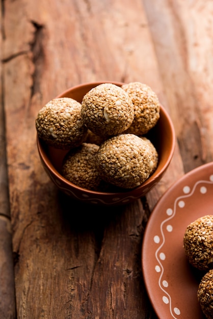 Tilgul Laddu ou Til Gul balls para makar sankranti, é um alimento saudável feito com gergelim, amendoim esmagado e açúcar mascavo. servido em uma tigela. foco seletivo mostrando detalhes.