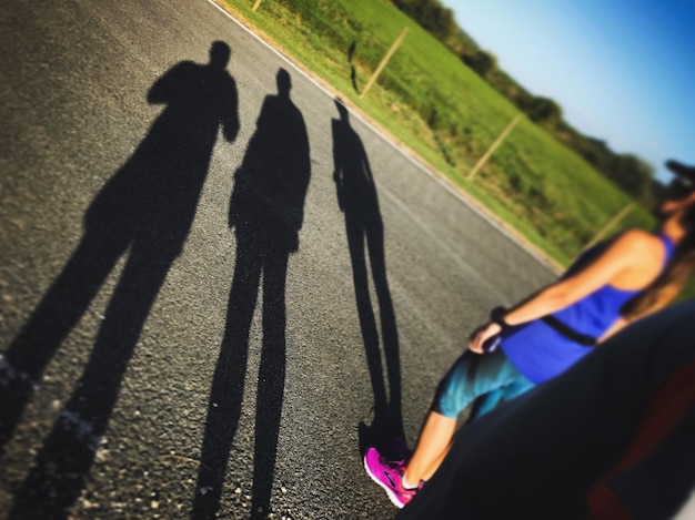 Tilt-Aufnahme von Menschen mit Schatten auf der Straße an einem sonnigen Tag