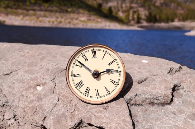 Time Concept Classic Vintage Reloj de bolsillo en las rocas volcánicas