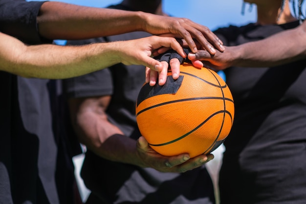Time de basquete unindo forças com as mãos