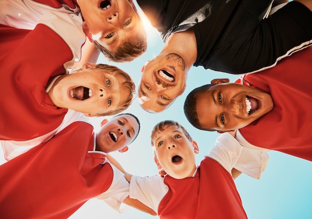 Time de futebol e treinador em comemoração e feliz com o vencedor do sorriso e o grupo de meninos do fundo Crianças do futebol animadas ou trabalho em equipe infantil para treinamento físico ou treino após jogo ou partida