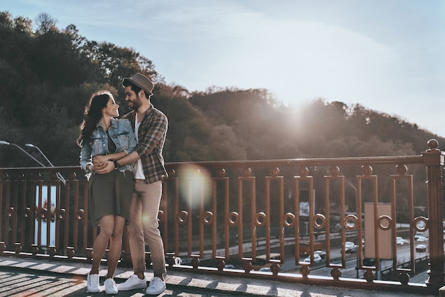 Ótimo encontro. Comprimento total de um lindo jovem casal se abraçando e olhando um para o outro