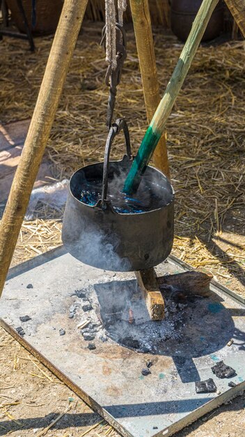 tingimento artesanal colorido de tecidos e lã em um caldeirão com corantes coloridos em uma feira medieval na Espanha