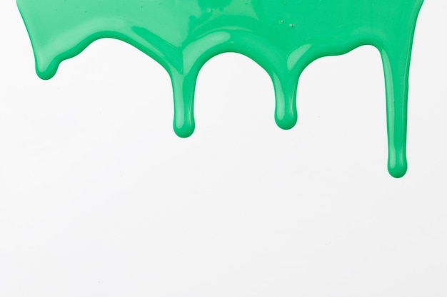 Tinta acrílica borrão pincelada caótica fluindo em fundo de papel branco criativo cor verde pano de fundo arte fluida
