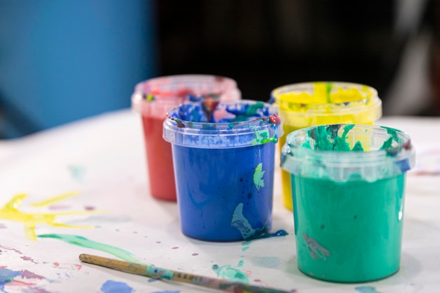 Tintas aquarela em frascos de cores diferentes no fundo de desenhos infantis Criatividade infantil