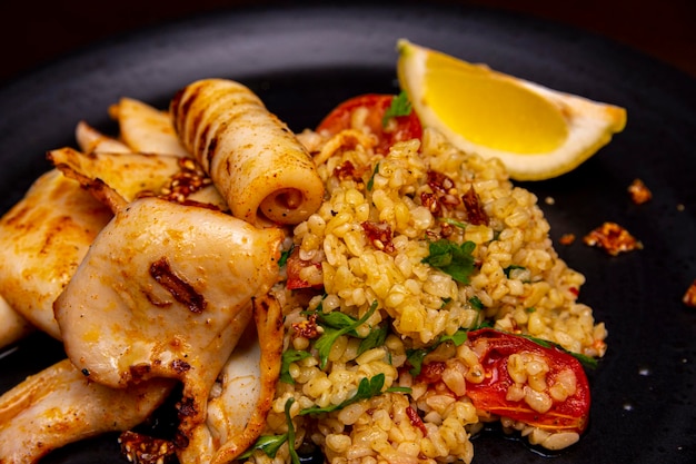 Tintenfisch mit einer Beilage aus Bulgur und getrockneten Tomaten Meeresfrüchte