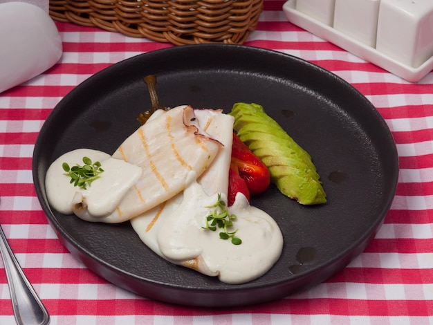 Tintenfisch mit eingelegtem Paprika und Avocado im Restaurant