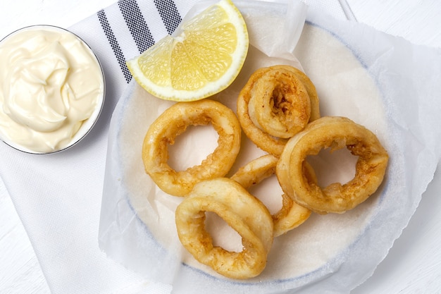 Foto tintenfischringe-sandwiches mit mayonnaise-sauce und zitrone. typisch spanisches essen. bocadillo de calamares. typisch spanisches essen