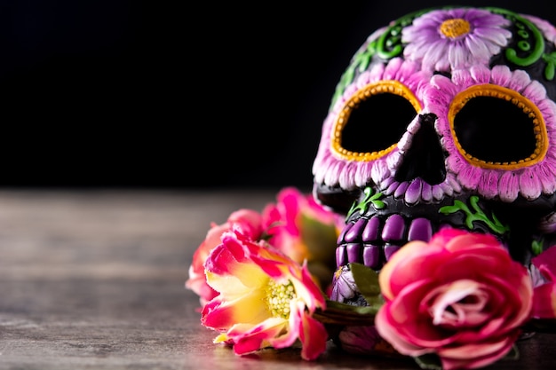 Típica calavera mexicana Katrina y diadema de flores sobre mesa de madera