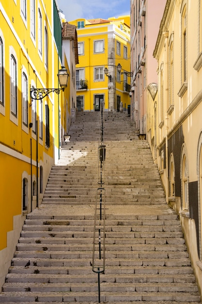 Típica calle empinada con largas escaleras y paredes coloridas de la ciudad de Lisboa, Portugal.