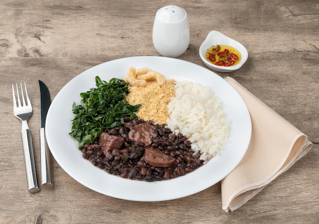 Típica feijoada brasileira com arroz pimenta farofa couve e torresmo