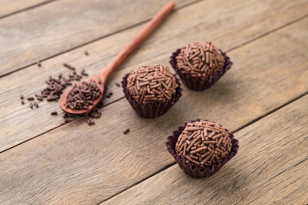 Típicos brigadeiros de chocolate brasileiros sobre mesa de madeira