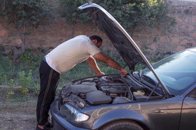 El tipo abrió el capó del coche y miró el motor.