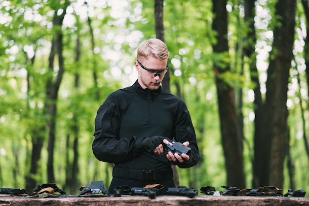 Un tipo en el bosque prueba sus armas para disparar deportes.