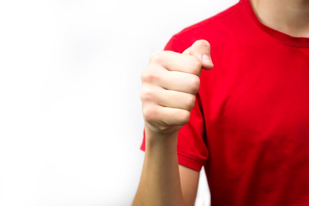 El tipo de la camiseta roja apretó el puño sobre una agresión de fondo blanco lista para pelear