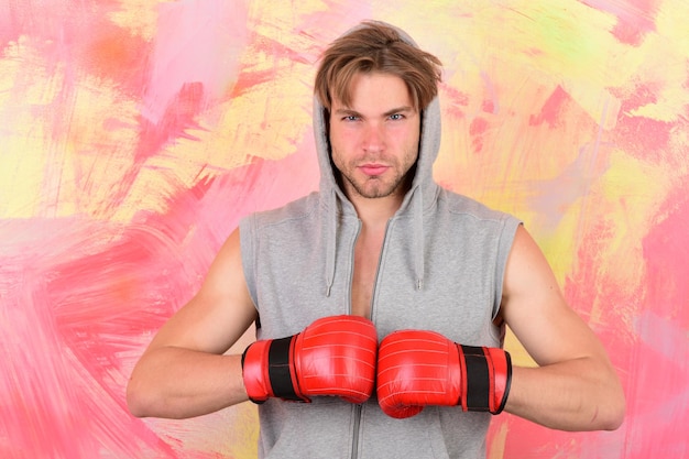 Foto el tipo con capucha gris sin mangas usa guantes de boxeo rojos