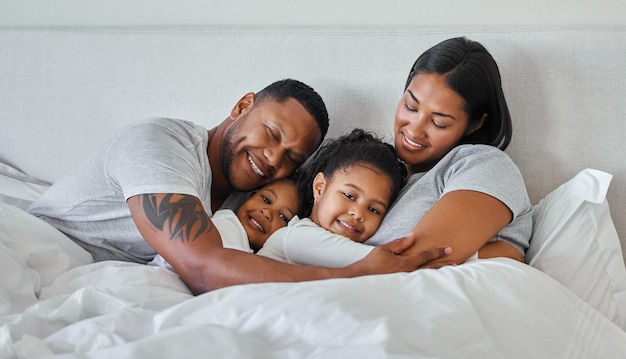 El tipo de corazón que brilla en la oscuridad. Foto de una hermosa familia joven hablando y uniéndose en la cama.