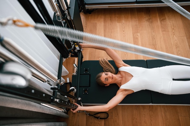 Foto tipo de cuerpo delgado mujer joven en el gimnasio está haciendo ejercicios