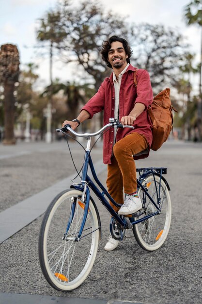 Un tipo de la generación Z está montando una bicicleta en una calle del centro de la ciudad.