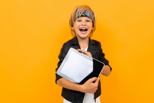 El tipo de moda con una sonrisa se ríe con una tableta en sus manos