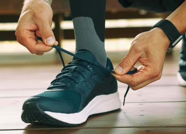 El tipo se prepara para correr y se ata las zapatillas