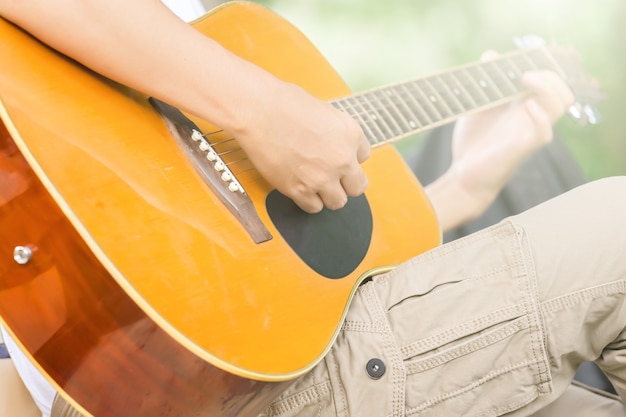 El tipo que toca la guitarra, al aire libre, pantalones cargo