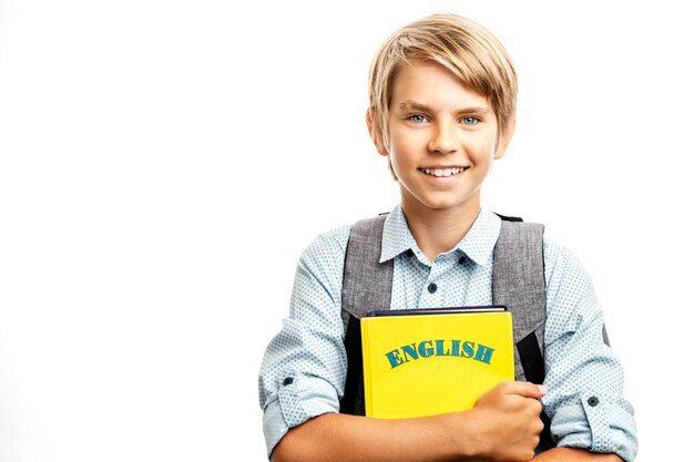 Tipo rubio sonriente con libros de texto en inglés