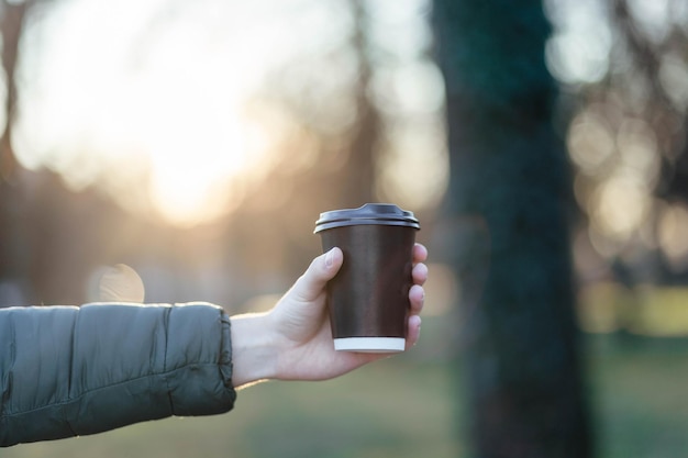 El tipo sostiene un vaso de papel con café o té Toma una taza de café Vaso de papel desechable Bebida caliente Espacio vacío Hombre parado en la calle sosteniendo una taza de café Buenos días