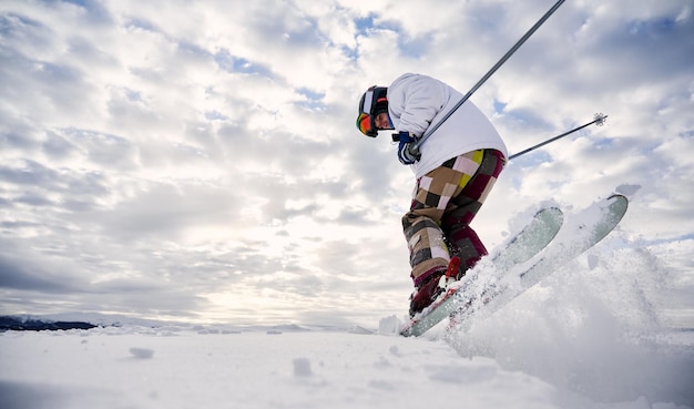 Tipos de esporte de inverno Esquiador fazendo truques nas montanhas na temporada de inverno